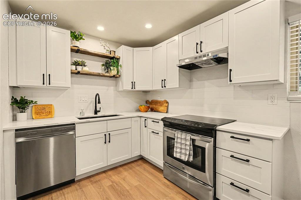 Image 3 of 18: Integrated trash, matte black sink and fixtures, modern subway tile backspl