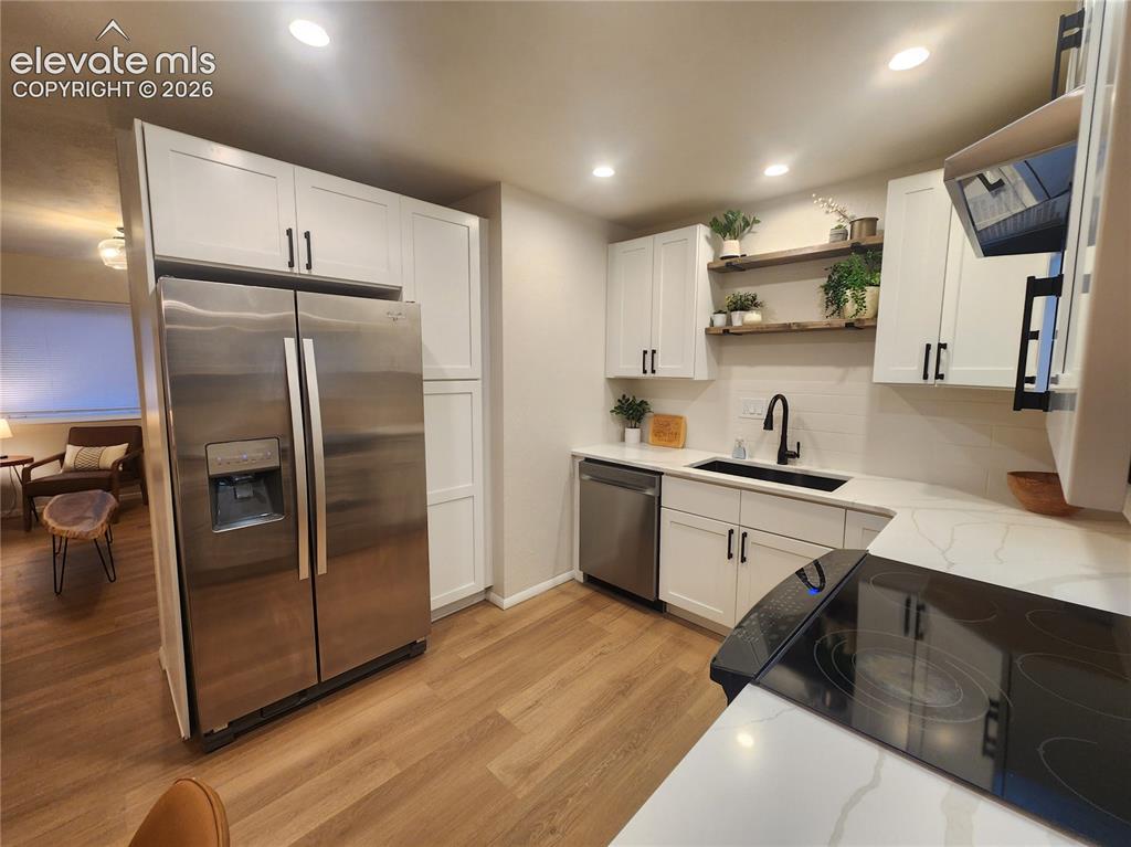 Image 6 of 22: Modern kitchen featuring large pantry, white shaker cabinetry, stainless st
