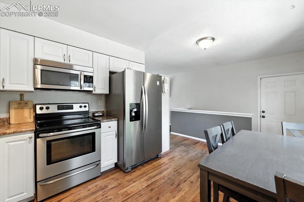 Image 13 of 43: Kitchen featuring stainless steel appliances, light wood flooring