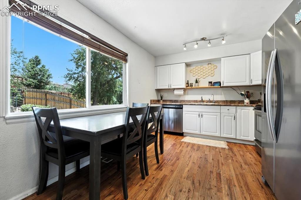 Image 14 of 43: Kitchen with appliances with stainless steel finishes, open shelves, wood f