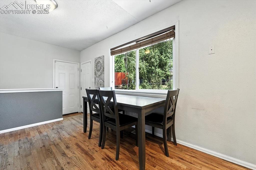 Image 15 of 43: Dining room featuring  wood finished floors, and a walkout to the backyard.