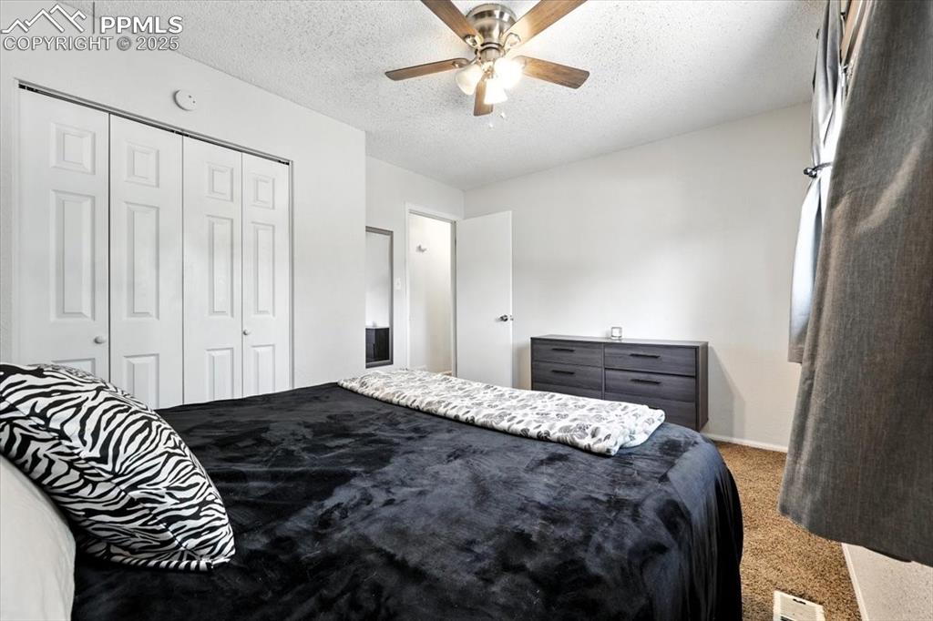 Image 18 of 43: Carpeted main Level Primary Bedroom.