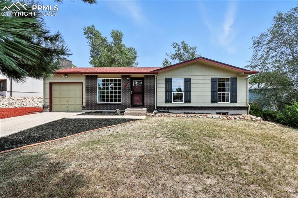 Image 2 of 43: Ranch-style home with an attached garage, a front yard driveway