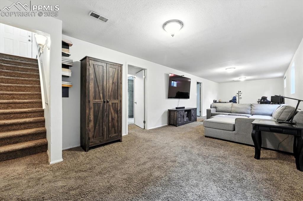 Image 24 of 43: Basement Family Room featuring carpet, stairway, and large living area