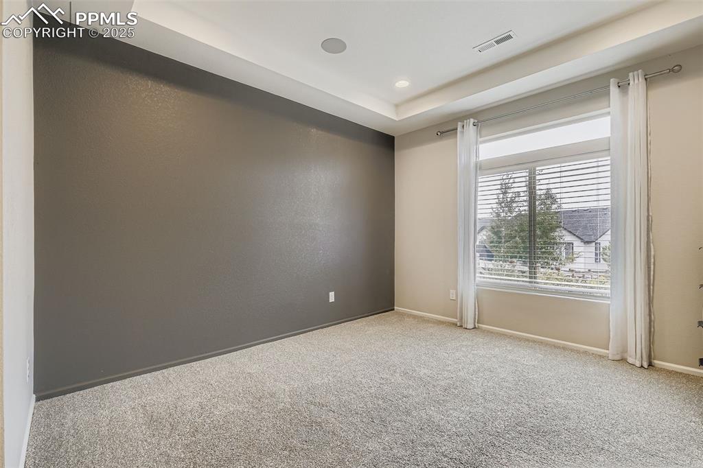 Image 12 of 28: Carpeted empty room with baseboards and a raised ceiling