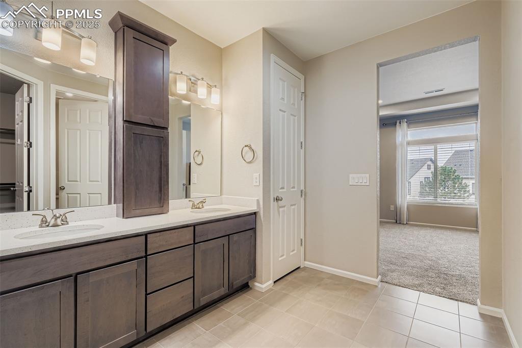 Image 15 of 28: Full bath with a closet, double vanity, and light tile patterned floors
