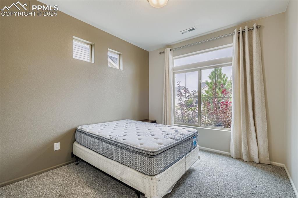 Image 18 of 28: Carpeted bedroom featuring baseboards and a textured wall