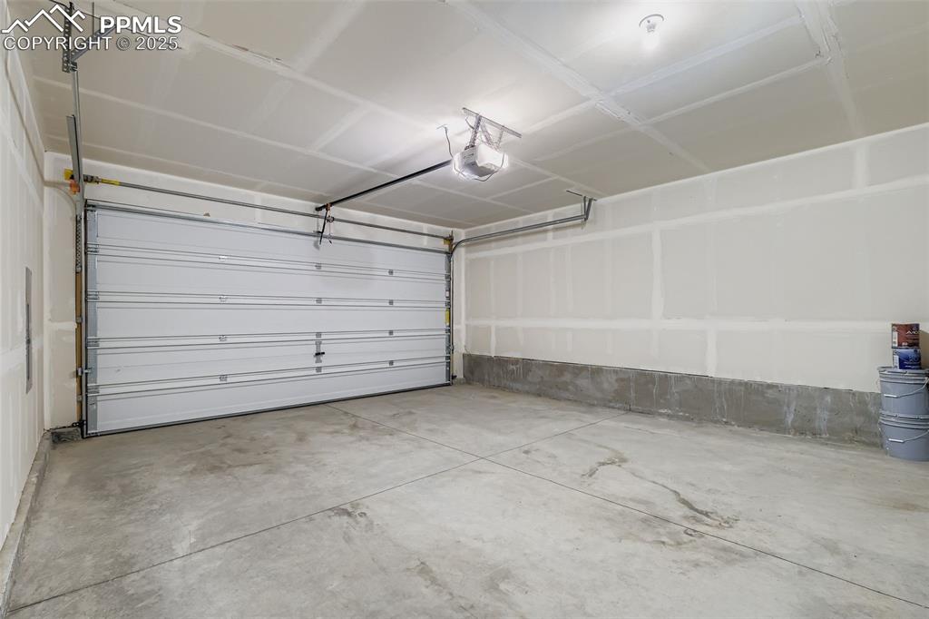 Image 26 of 28: Garage featuring a garage door opener