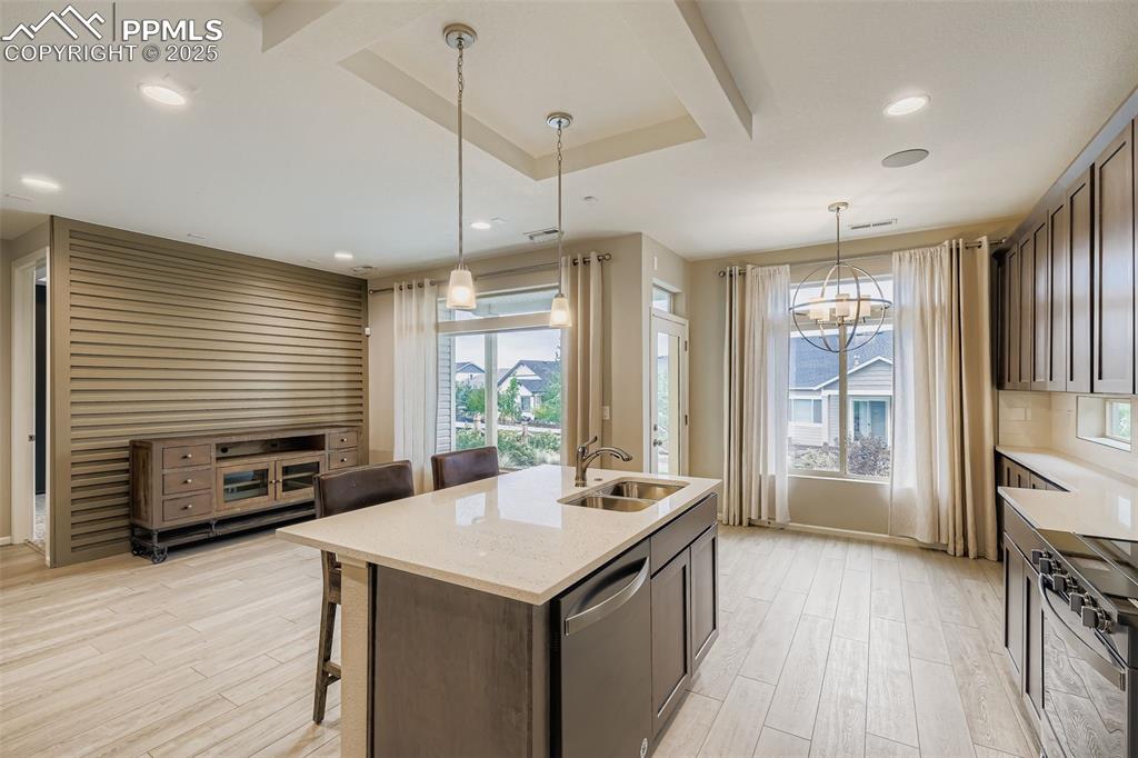 Image 7 of 28: Kitchen featuring a kitchen breakfast bar, decorative light fixtures, a kit