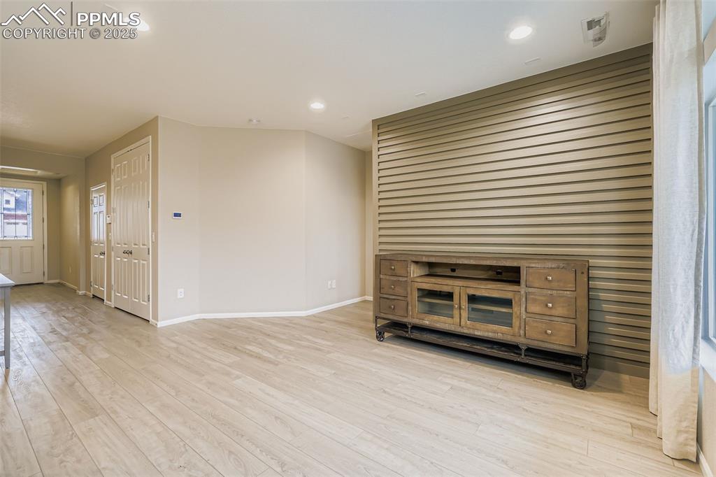 Image 8 of 28: Empty room with light wood-style flooring and recessed lighting
