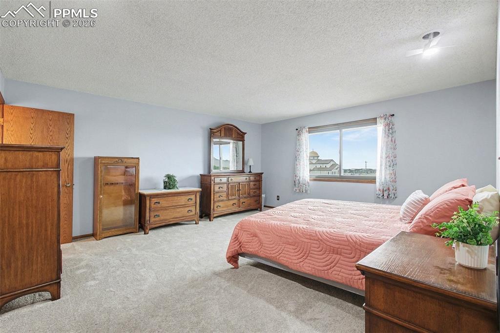 Image 12 of 34: Bedroom with carpet floors and a textured ceiling