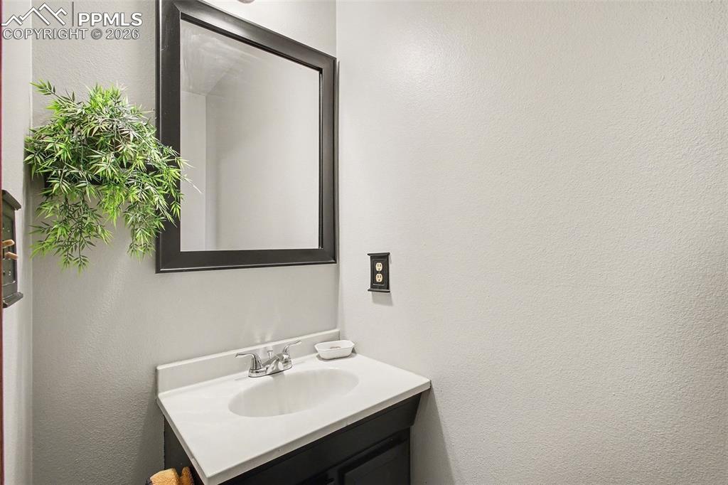 Image 18 of 34: Bathroom featuring a textured wall and vanity