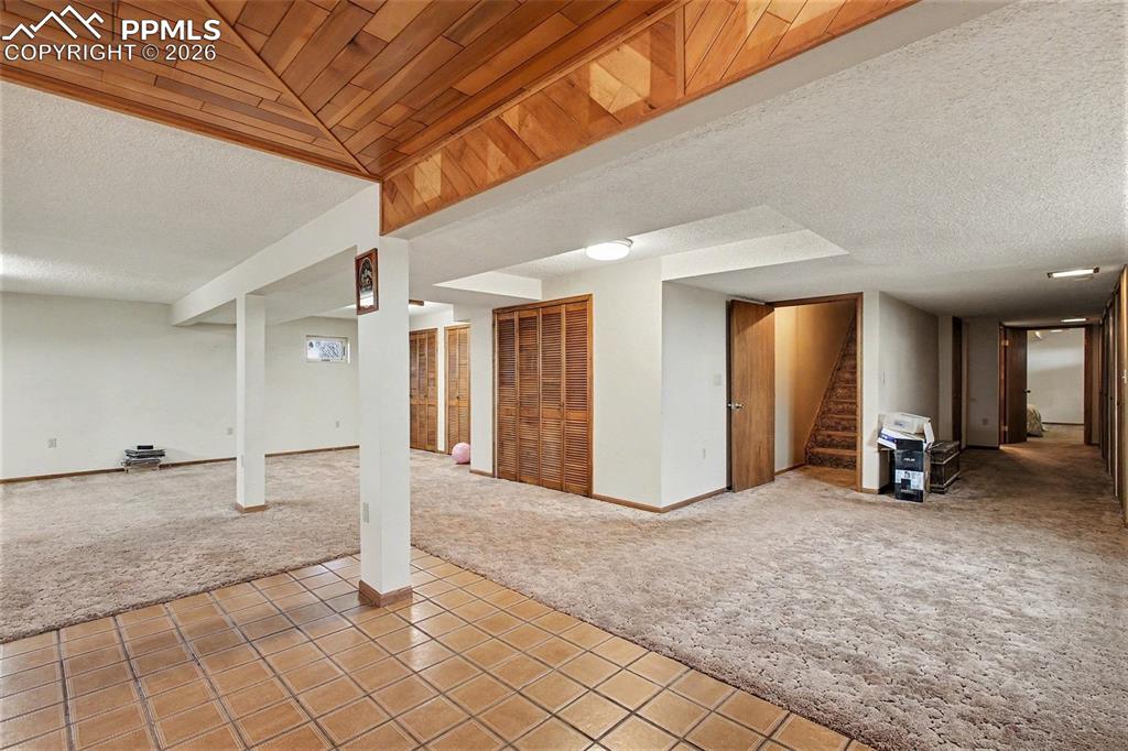 Image 21 of 34: Finished below grade area with light colored carpet, a textured ceiling, an