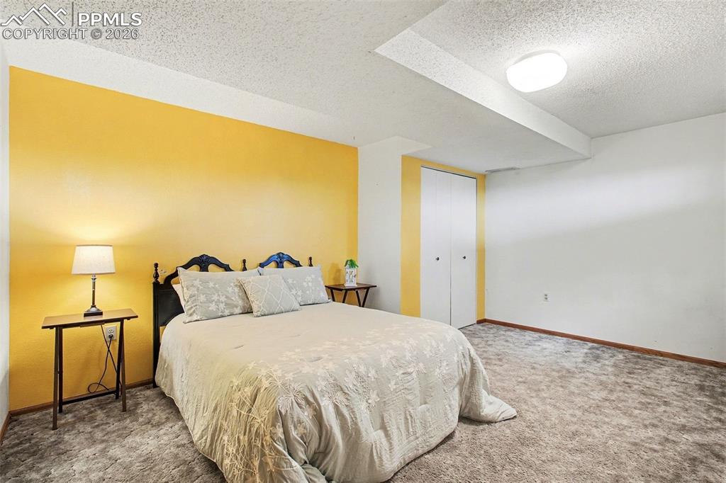 Image 23 of 34: Bedroom featuring a textured ceiling, carpet flooring, and a closet