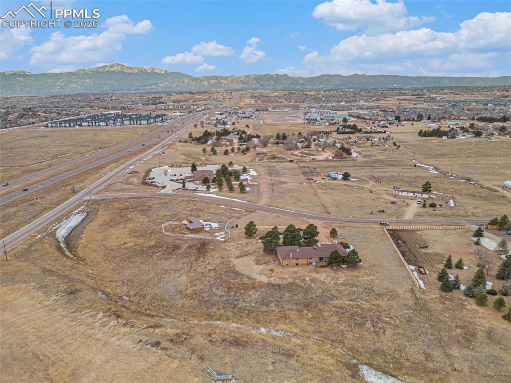 Image 30 of 34: Aerial view of property and surrounding area featuring a mountain backdrop 