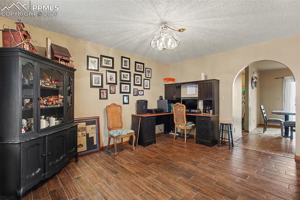 Image 7 of 34: Office area with a textured ceiling, hanging lights, arched walkways, and w