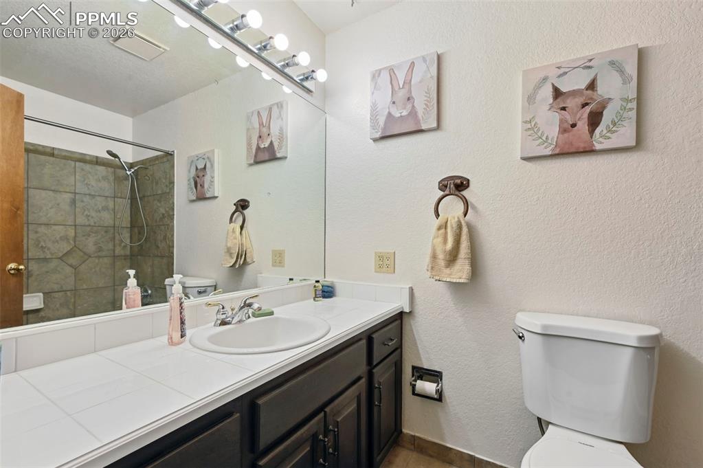 Image 12 of 27: The bathroom features a vanity with a white countertop and a built-in sink,