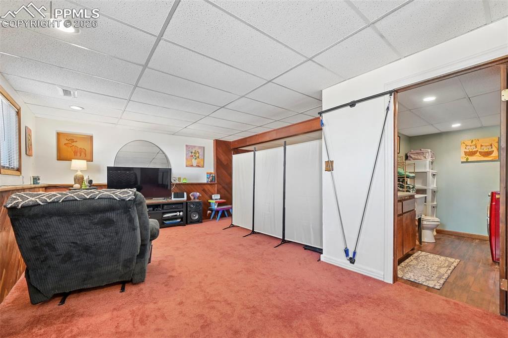 Image 16 of 27: This versatile area features a carpeted floor and recessed lighting