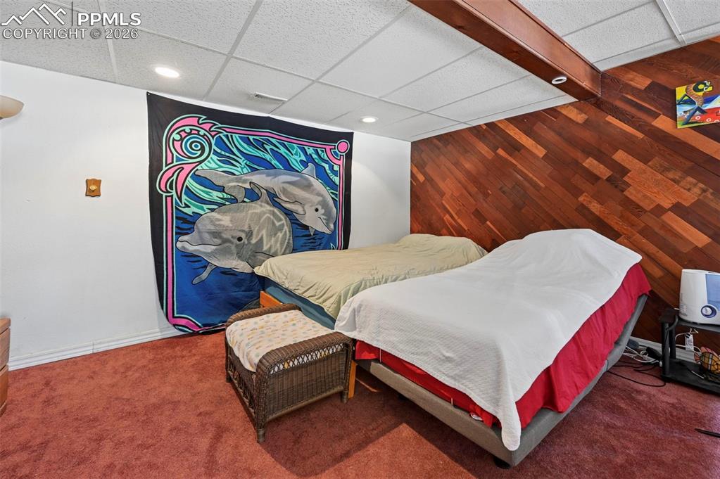 Image 18 of 27: The room features a textured drop ceiling with recessed lighting, a promine