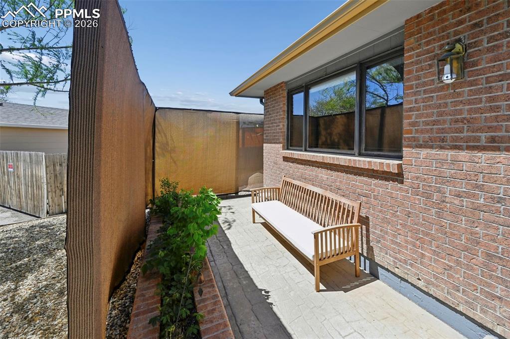 Image 24 of 27: The property features a brick exterior with windows, an exterior light fixt