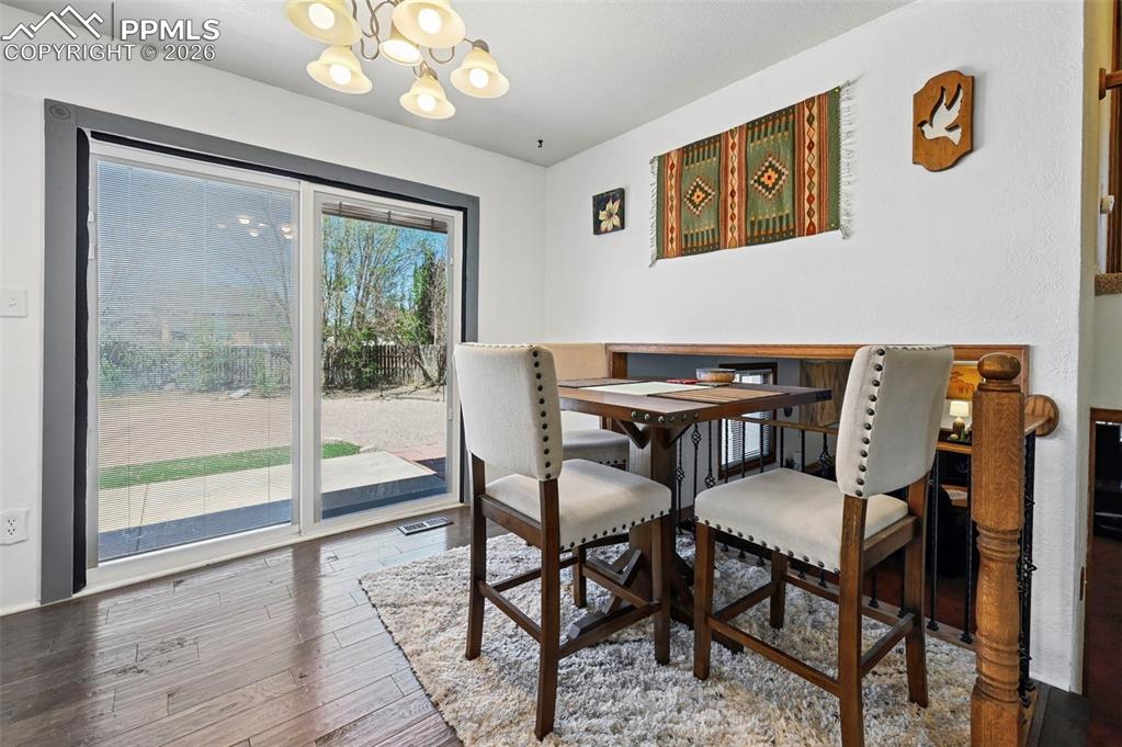 Image 6 of 27: Dining area featuring hard surface flooring, a sliding glass door providing