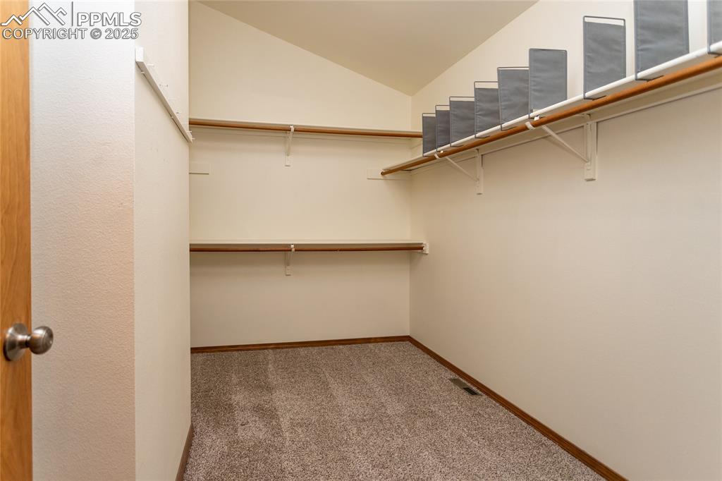 Image 25 of 48: Walk-in closet in primary bedroom