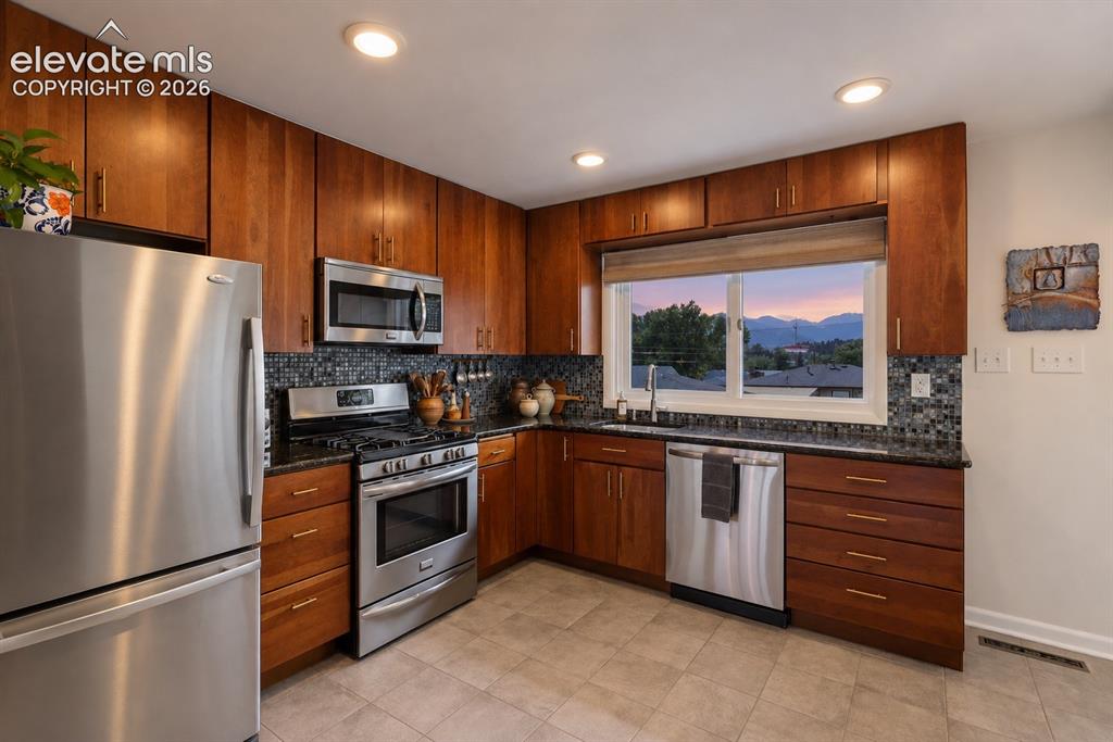 Image 10 of 36: Updated kitchen with rich cabinetry, stainless appliances and beautiful mou