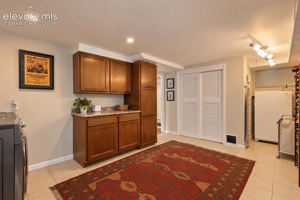 Image 27 of 36: Exceptional laundry room with utility sink, abundant cabinetry, stone count