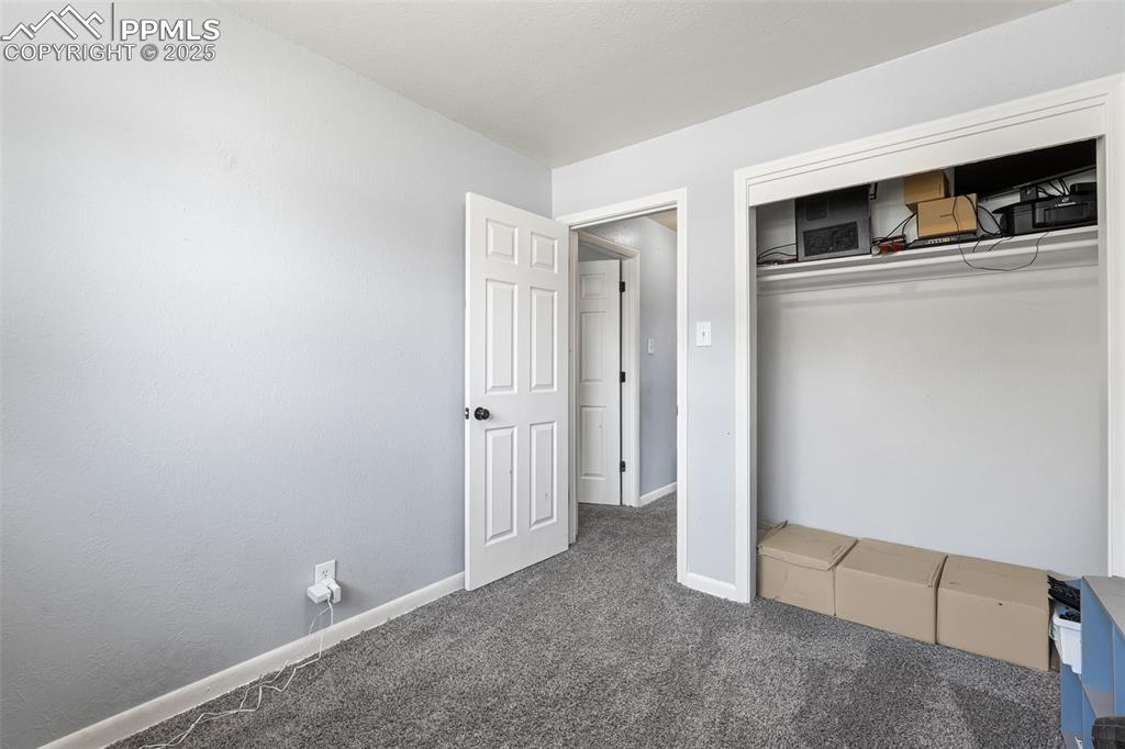 Image 10 of 24: Unfurnished bedroom featuring carpet, baseboards, and a closet