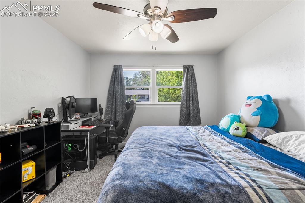 Image 12 of 24: Carpeted bedroom featuring a ceiling fan and an office area