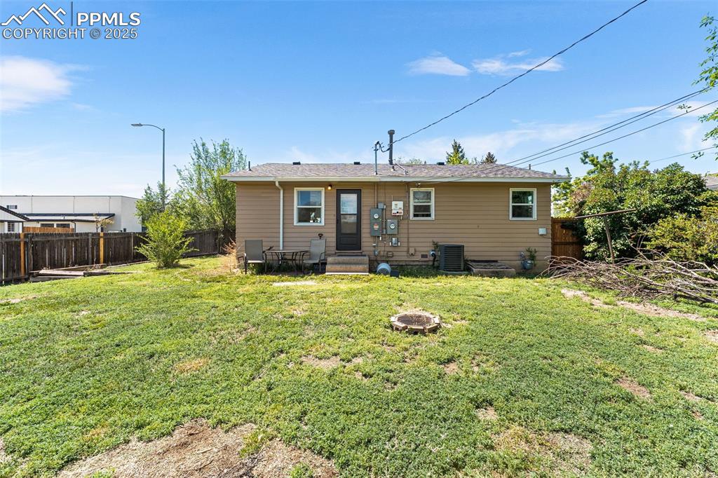 Image 20 of 24: Rear view of house featuring central AC and a fire pit