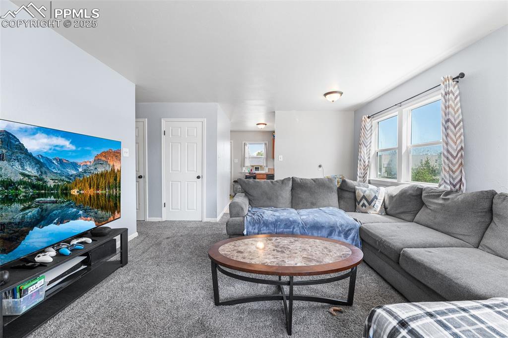 Image 4 of 24: Carpeted living area with baseboards