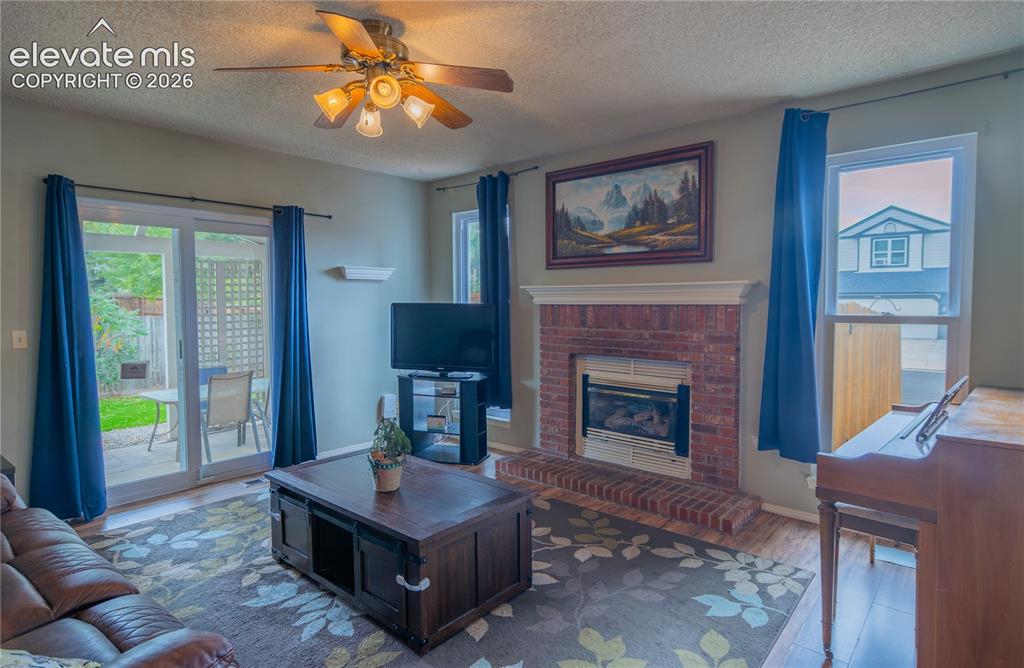 Image 11 of 42: Brick fireplace with a gas insert and a white mantel