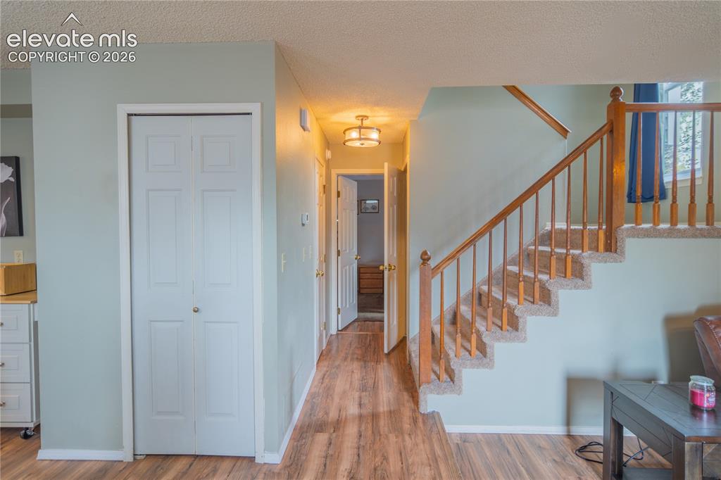Image 15 of 42: Wood-finish flooring throughout, carpeted staircase with wood banister and