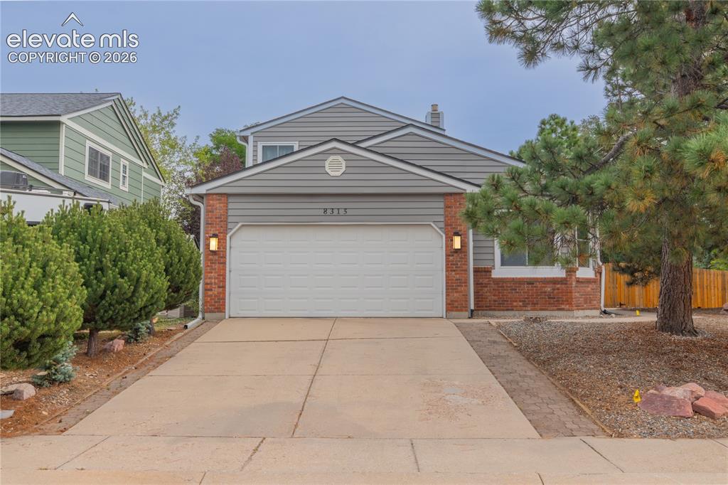 Image 2 of 42: Exterior featuring brick accents, horizontal siding, an attached garage, a 