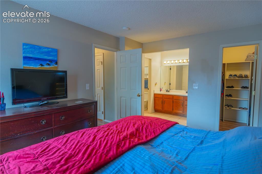 Image 20 of 42: Integrated bathroom access, walk-in closet with built-in shelving, vanity w