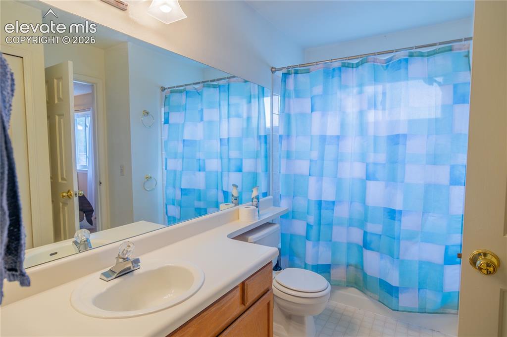 Image 21 of 42: Bathroom featuring a single-sink vanity with wood-finish cabinetry, a large