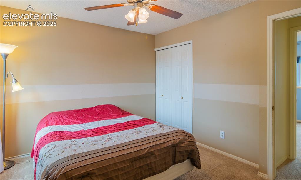 Image 23 of 42: Carpeted room featuring a ceiling fan with light fixture and bifold closet 