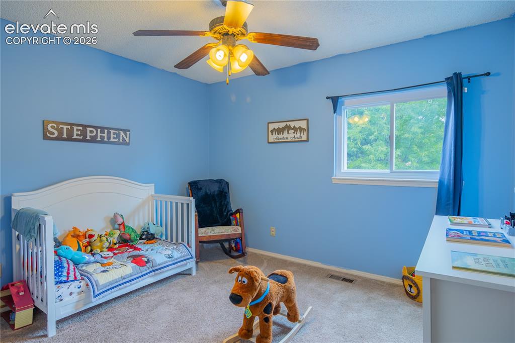 Image 24 of 42: Carpeted room featuring a ceiling fan with integrated lighting, a window wi