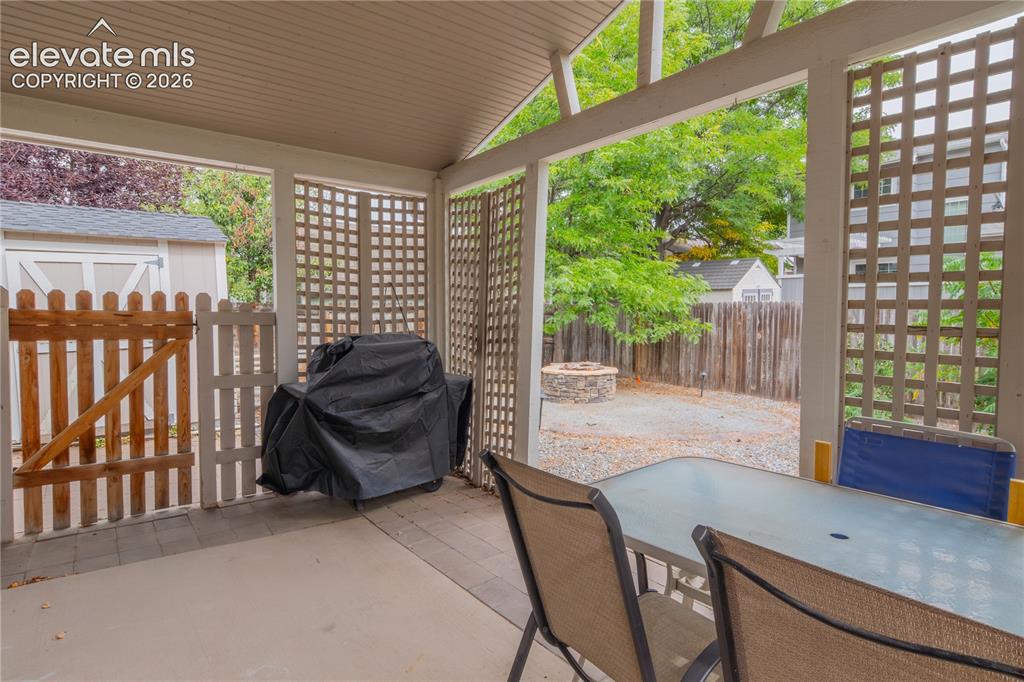 Image 41 of 42: Covered patio with concrete flooring, lattice privacy screens, and a wood p