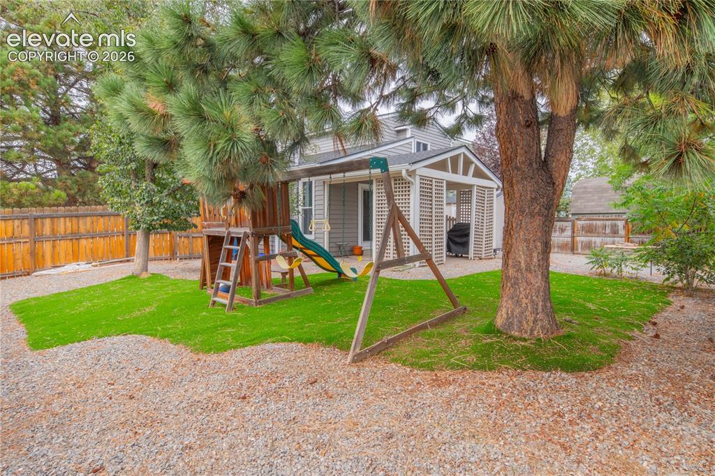 Image 42 of 42: Backyard featuring a covered patio, a privacy trellis, an artificial turf a