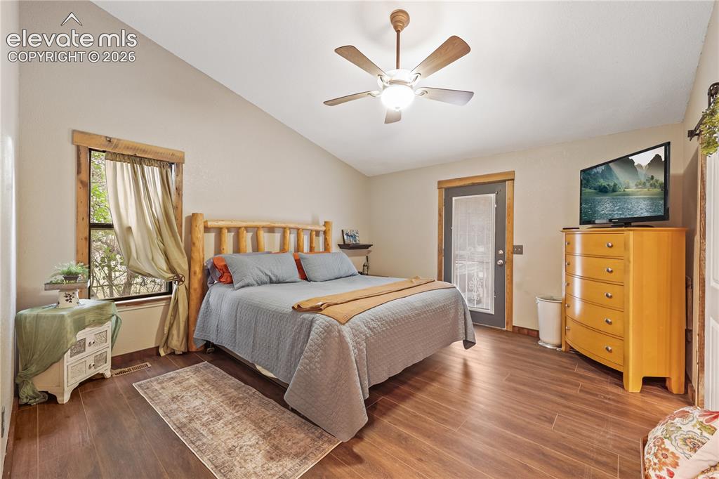 Image 16 of 50: Primary bedroom with door to the deck and hot tub!