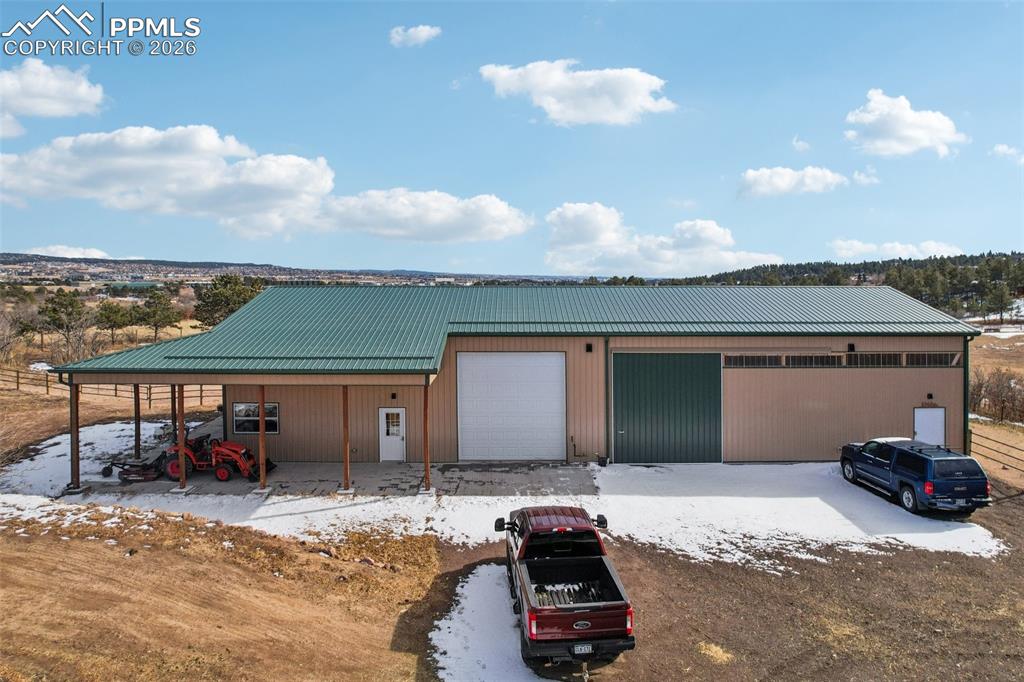 Image 24 of 40: View of front of house featuring a metal roof, a detached garage, and an ou