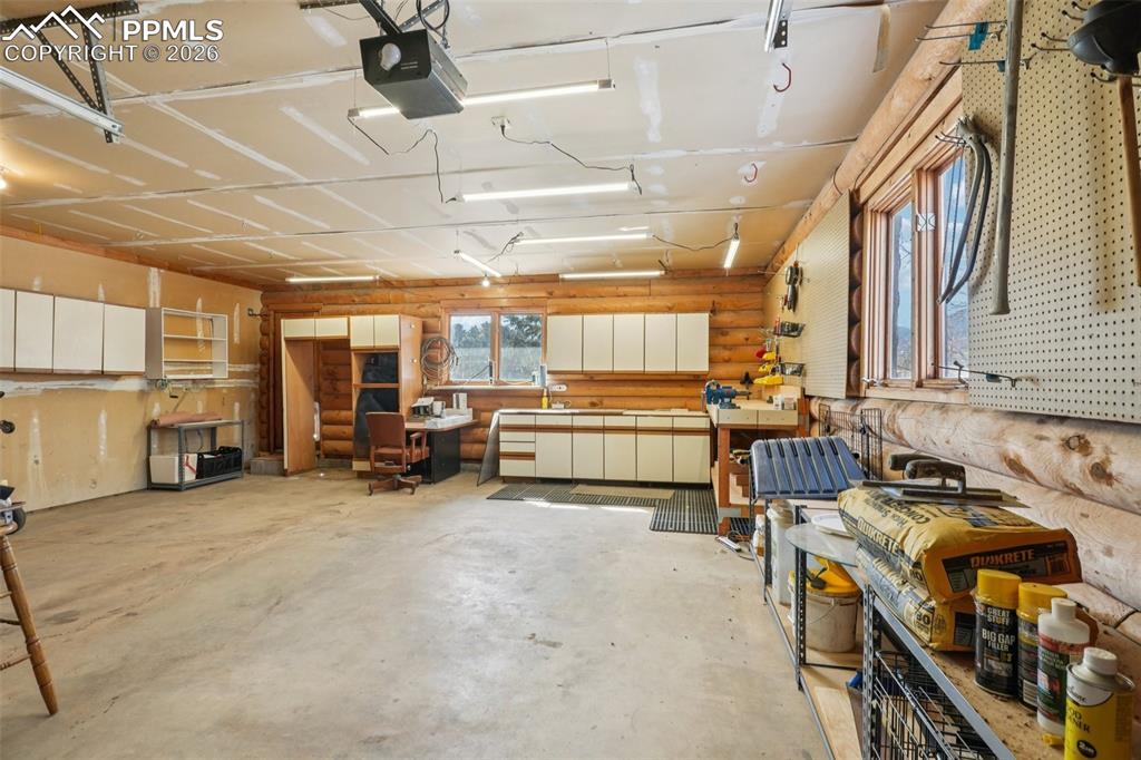 Image 27 of 40: Garage featuring a workshop area and a garage door opener