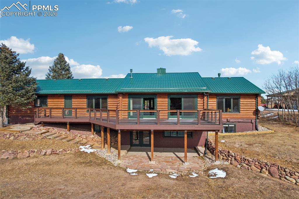 Image 32 of 40: Rear view of property featuring a deck, a patio area, and a metal roof