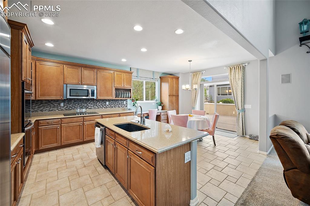 Image 14 of 50: Large eat in Island beautiful, tiled flooring and walk out to the wonderful