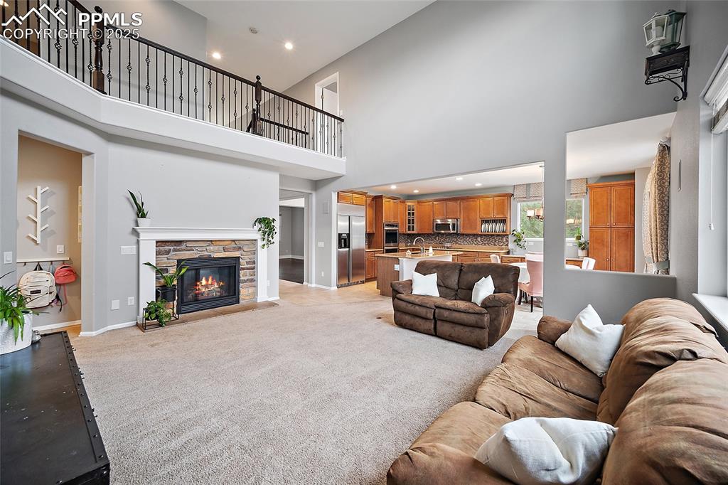 Image 15 of 50: Open concept for the living room and kitchen. Gas fireplace gives this spac