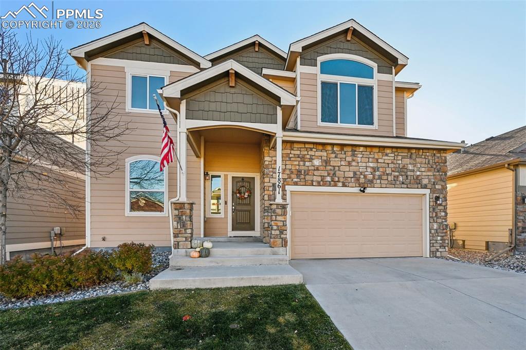 Image 1 of 38: Craftsman-style home with a garage, driveway, and stone siding