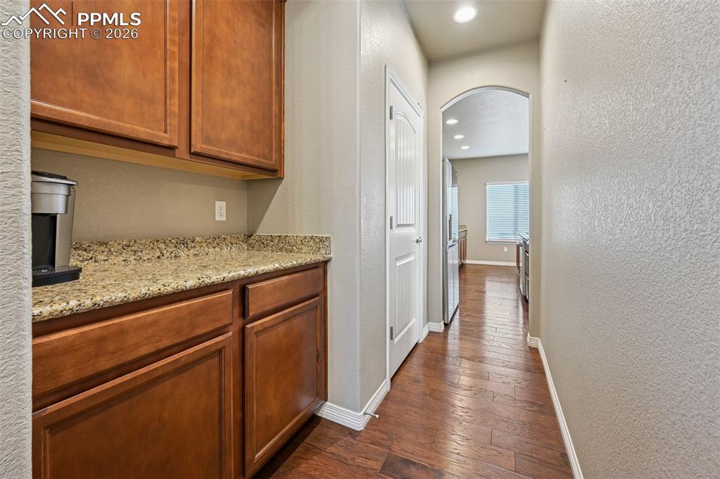 Image 11 of 38: Corridor featuring arched walkways, dark wood-style floors, recessed lighti