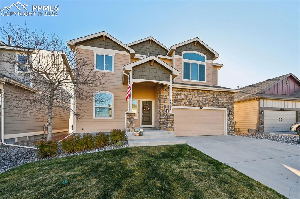 Image 2 of 38: Craftsman house featuring concrete driveway, an attached garage, stone sidi
